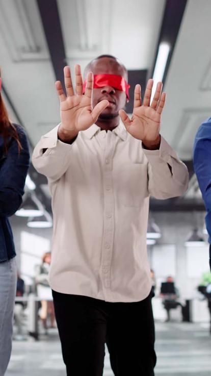 Geblinddoekte man loopt door kantoor