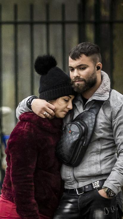 vluchtelingen omhelzen elkaar buiten het azc