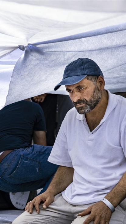 asielzoeker wacht buiten voor het azc