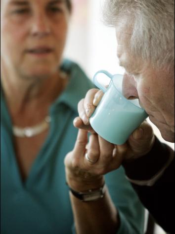 mantelzorger helpt haar oude moeder met drinken