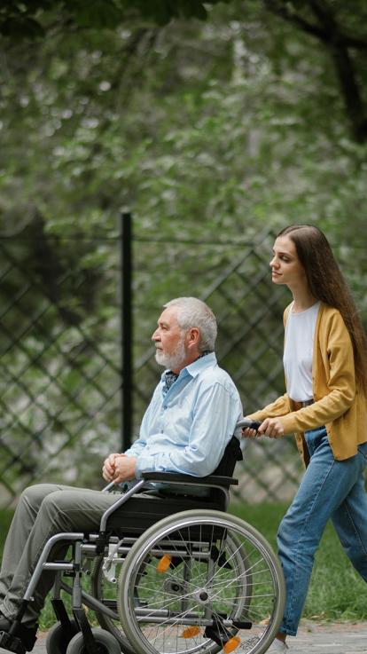 mantelzorger duwt rolstoel 