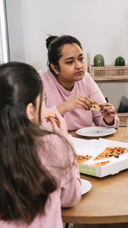 gezin aan tafel eet pizza
