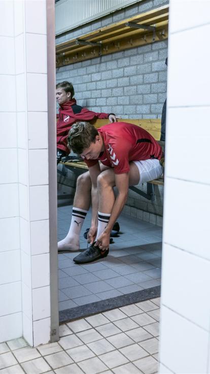 iemand kleed zich aan in voetbalkleedkamer