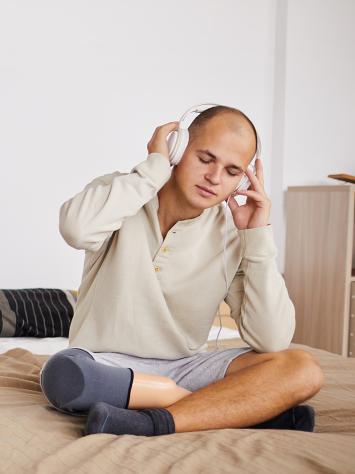 iemand luistert op z'n bed naar muziek uit z'n koptelefoon