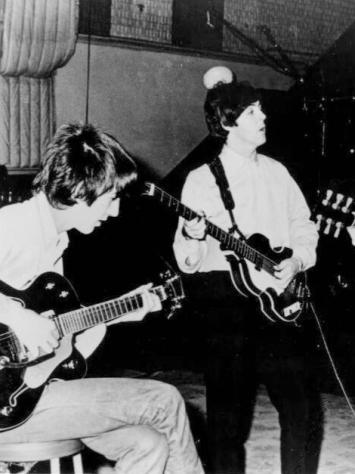 een zwart-witfoto van The Beatles die samen repeteren 