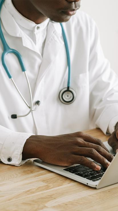 Een dokter bekijkt een dossier op een computer