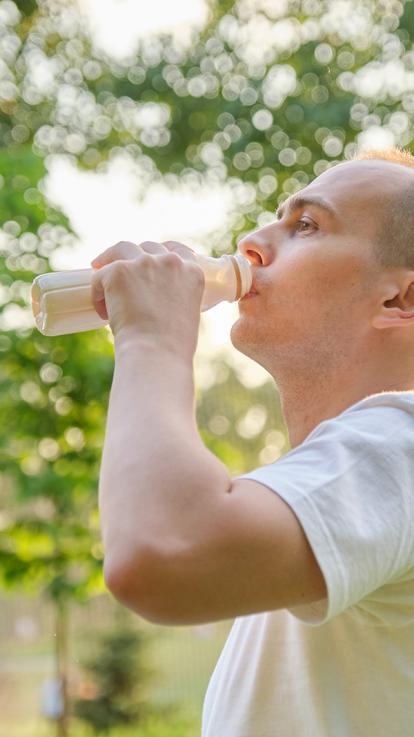 Man neemt slokje uit flesje drinken