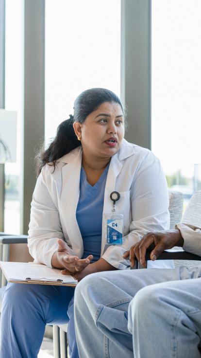 Vrouw in doktersuniform heeft gesprek met twee mannen in een wachtkamer