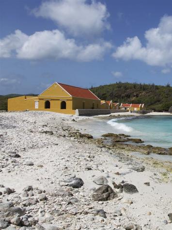 een foto van een geel huis aan de kust van het eiland Bonaire