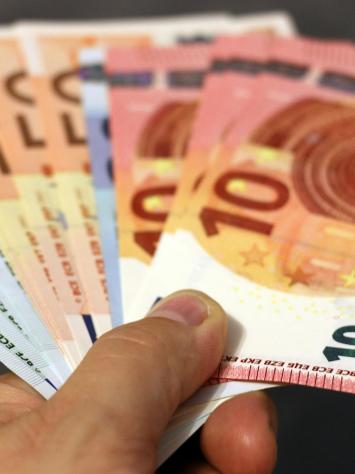 iemand houdt eurobiljetten vast in zijn hand