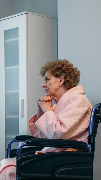 een oude vrouw die op haar bed gaat zitten