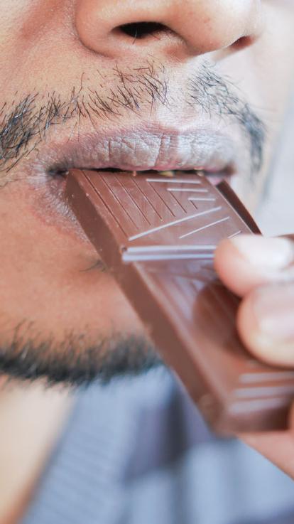 iemand neemt een hap chocola