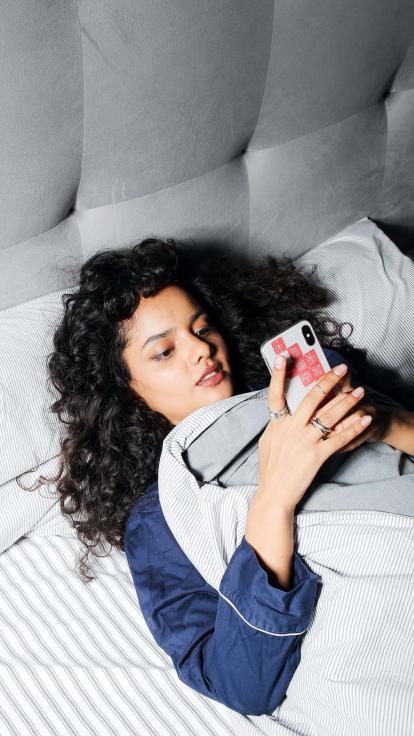 Kijkt naar haar telefoon in bed