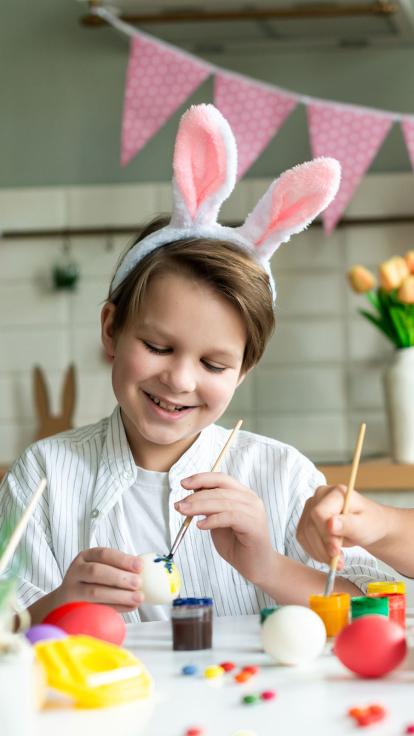 een kind is paaseieren aan het schilderen