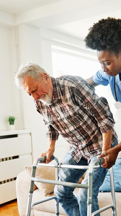 verzorger helpt iemand van de bank afkomen