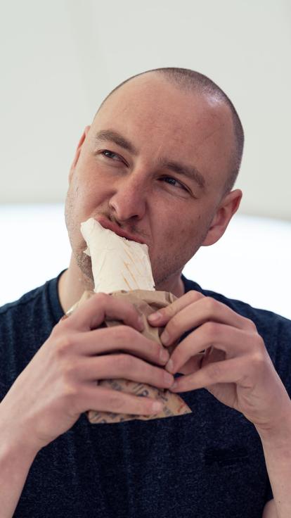 iemand neemt een hap van een wrap