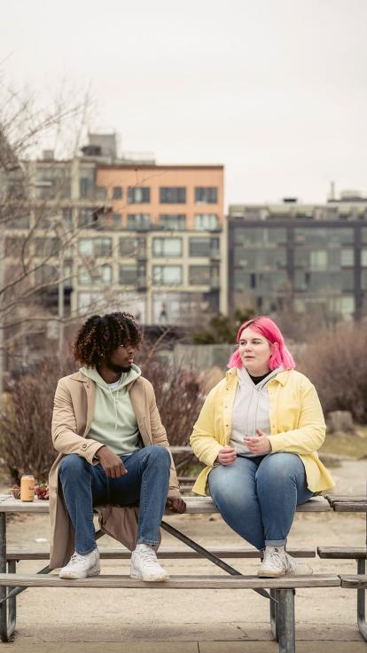 twee mensen zitten op een bankje, eentje heeft overgewicht