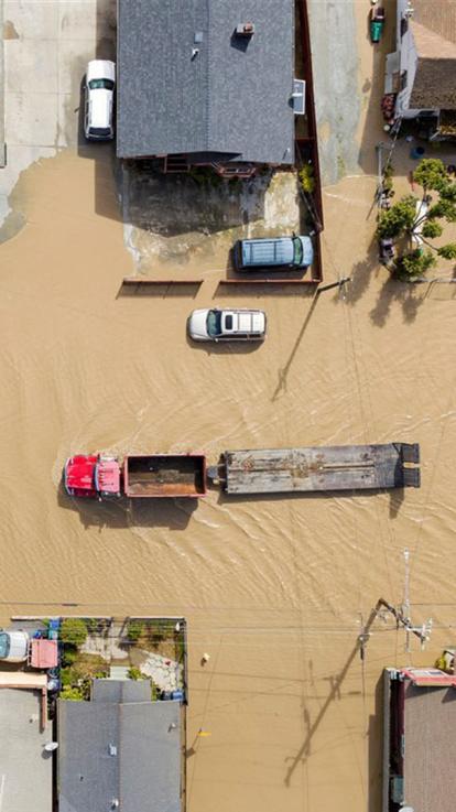 Een straat in een woonwijk, is helemaal overstroomd. 