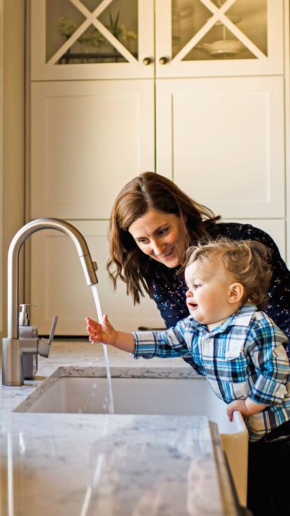 kind en moeder kijken naar kraan