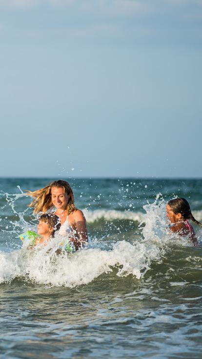 een familie zwemt en speelt in de zee