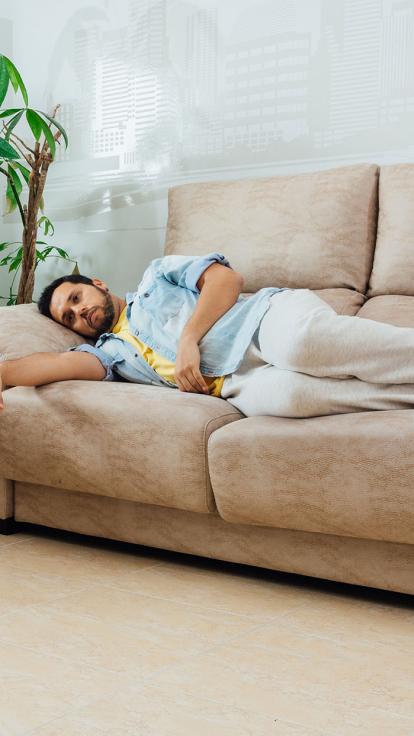 iemand ligt moe op de bank