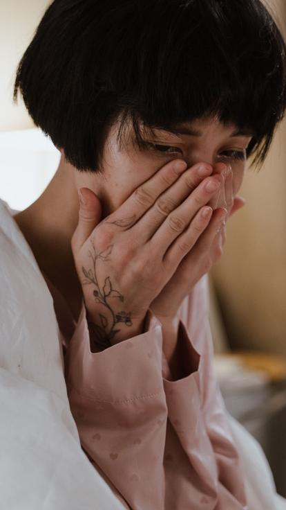 iemand slaat de handen voor het gezicht