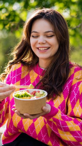 iemand eet groenten van een poké bowl