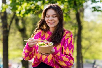 iemand eet groenten van een poké bowl
