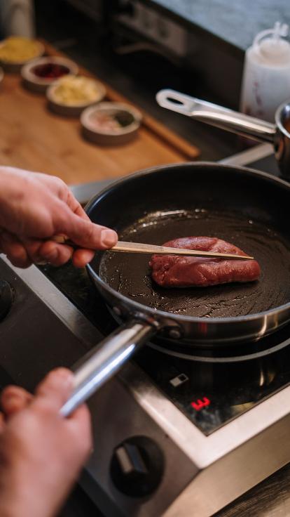 iemand braadt een stukje vlees