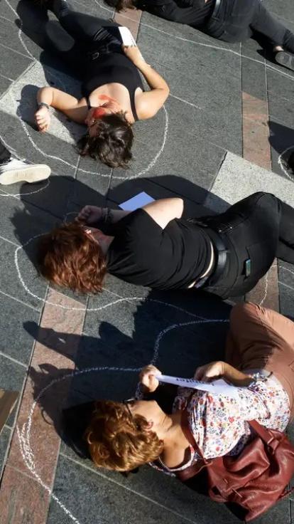 protest tegen femicide door vrouwen die op de grond liggen in kalktekeningen