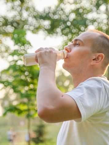 Man drinkt uit flesje melk
