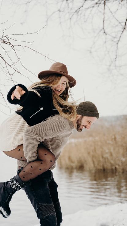 Een man tilt zijn geliefde op zijn rug. 