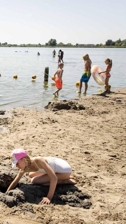 bezoekers bij een zwemplas met strand in Nederland