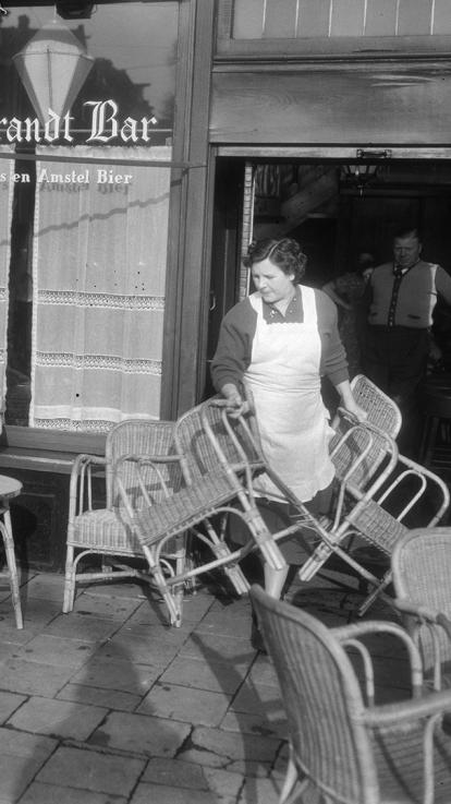 Vrouw zet een terras buiten aan het Rembrandtplein. 