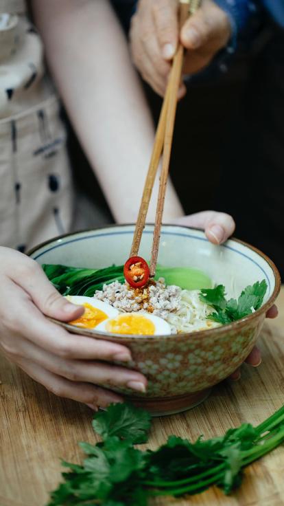 ramen waar een stukje chilipeper op wordt gelegd