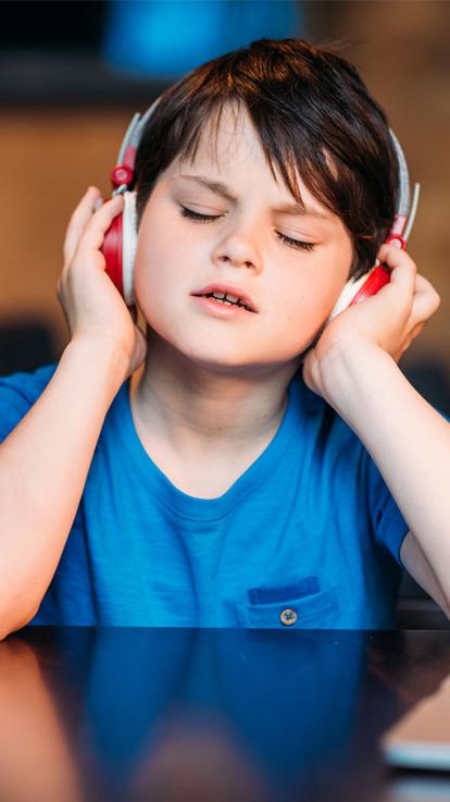 Een jongen die muziek luistert.