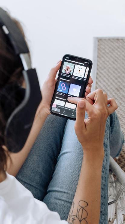 Iemand zoekt op spotify, een streamingdienst, naar muziek.