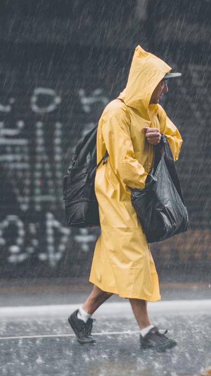 persoon in de regen met regenkleding