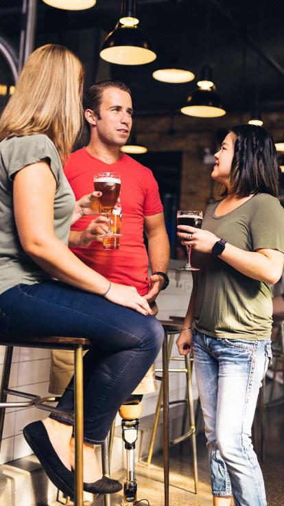 drie mensen praten op een borrel