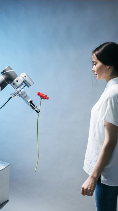 Een slimme AI-robot heeft interactie met een mens en geeft deze een bloem. 