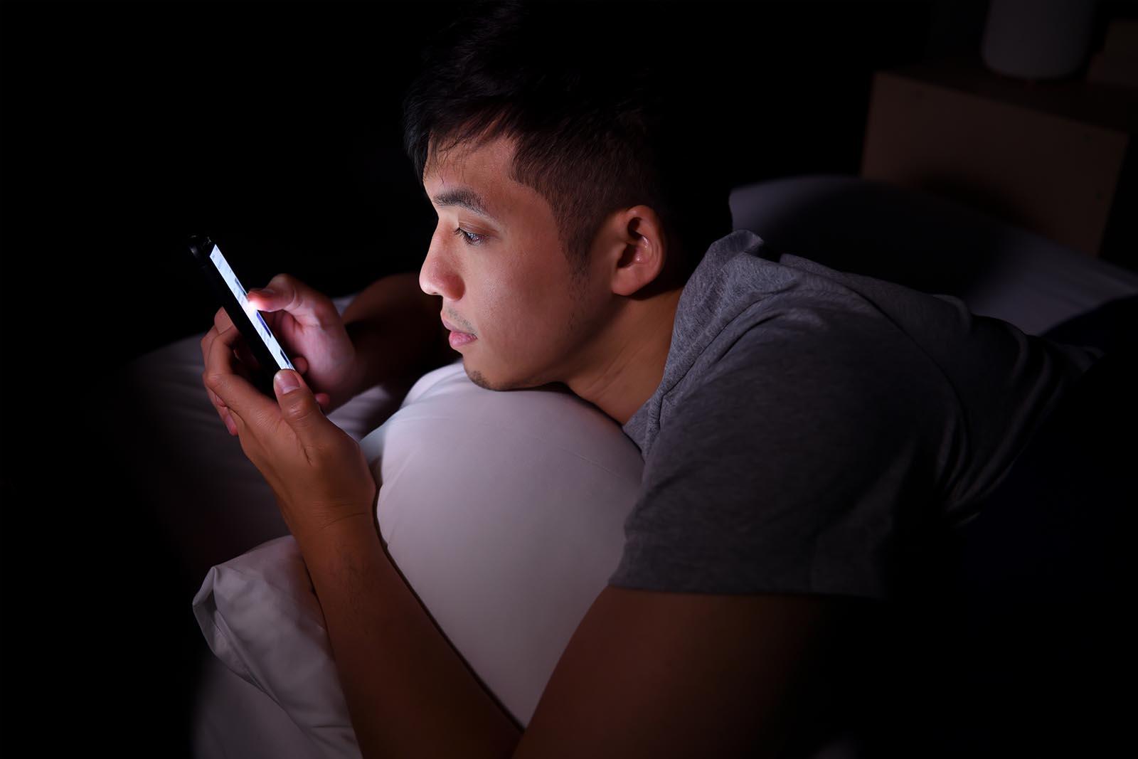 iemand kijkt op zijn telefoon in het donker