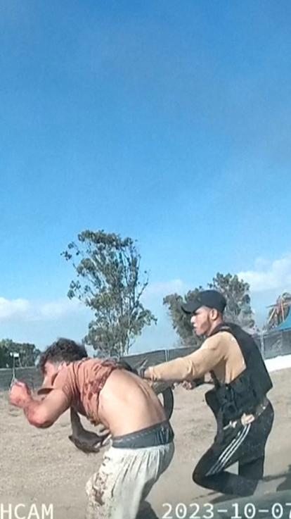 Een strijder van Hamas gijzelt een Israëlier, in oktober 2023. 