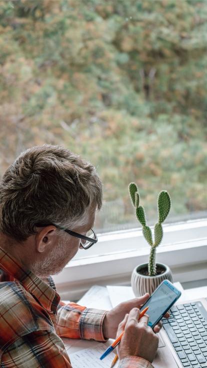 iemand rekent iets uit op zijn mobiel