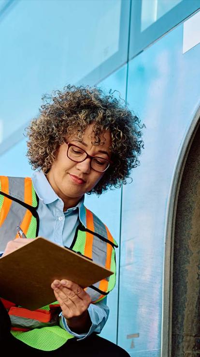 Vrouw staat voor bus.