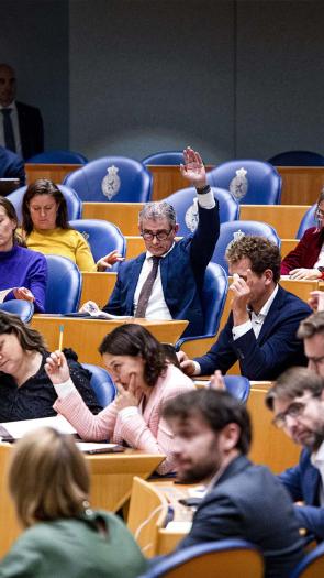 Tweede Kamerleden steken hun hand op tijdens stemmen