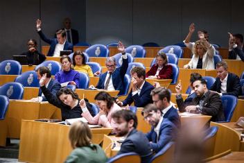 Tweede Kamerleden steken hun hand op tijdens stemmen
