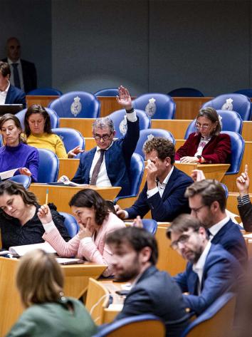 Tweede Kamerleden steken hun hand op tijdens stemmen
