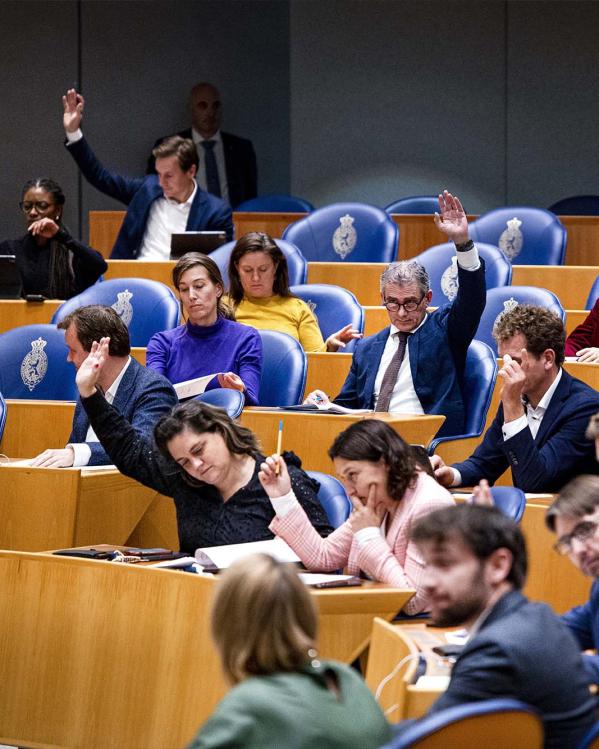 Tweede Kamerleden steken hun hand op tijdens stemmen