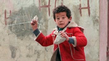 een kind gooit stenen naar Israëlische soldaten