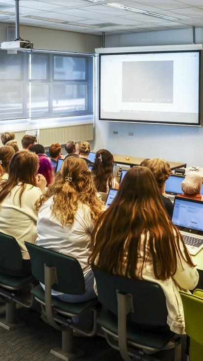 Groep studenten drinkt bier, bij hun studentenhuis. 